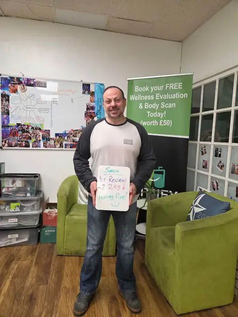 A member shows his assessment on a whiteboard, in the club room