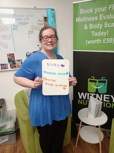 A member shows her assessment on a whiteboard, in the club room